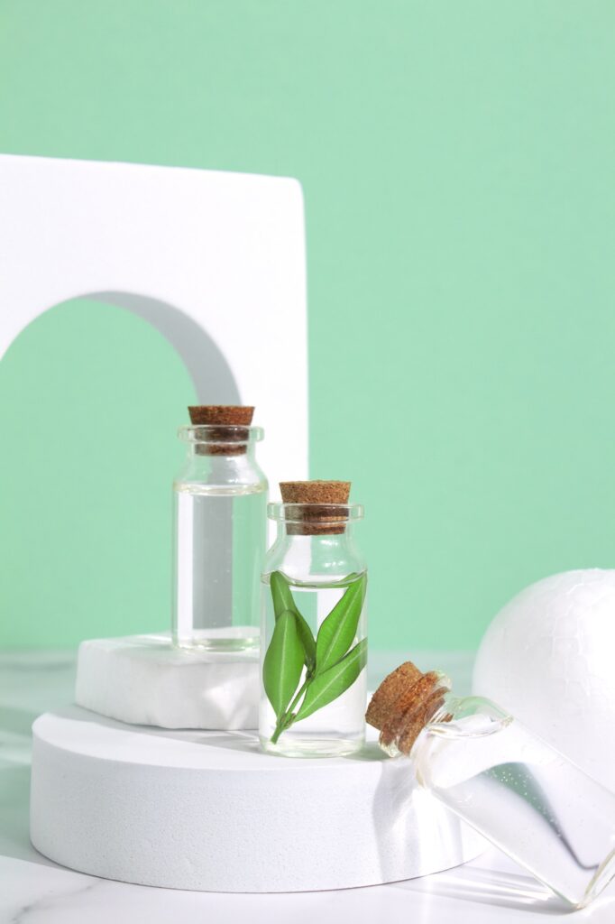 Little glass vial of aroma essential oil on podium in arch. Natural skin care product concept