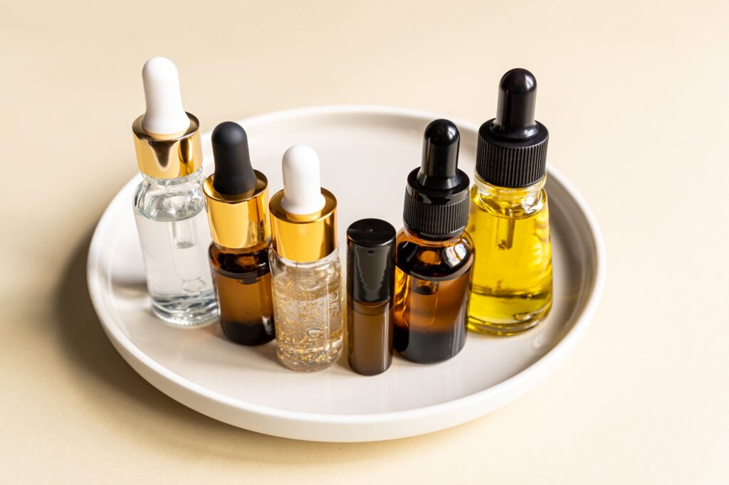 set of different dropper bottles with beauty care serum, hyaluronic acid and vitamins on tray