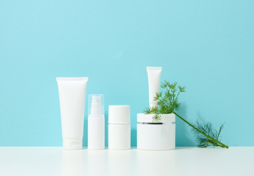 Empty white plastic tubes and jars for cosmetics. Packaging for cream, gel