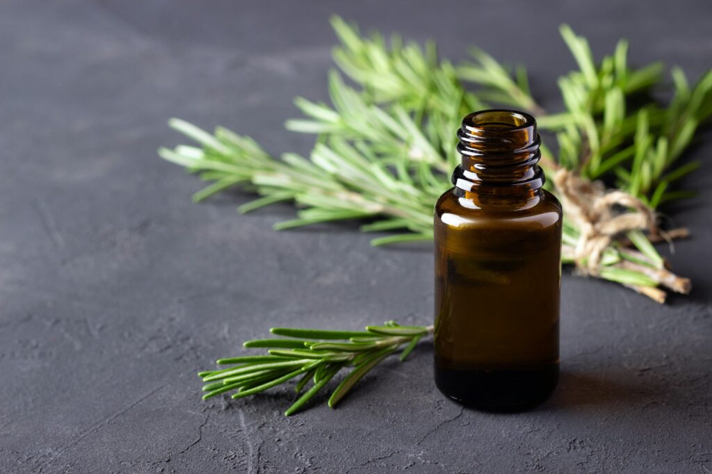 A bottle of essential oil with rosemary